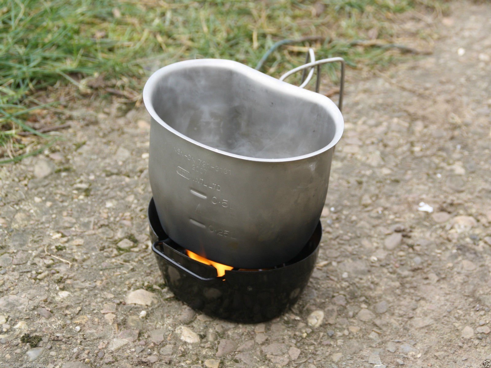 Crusader Cooking Set Black with stainless steel mug steaming on top of a black cooking base, designed for outdoor use and compact cooking solutions.